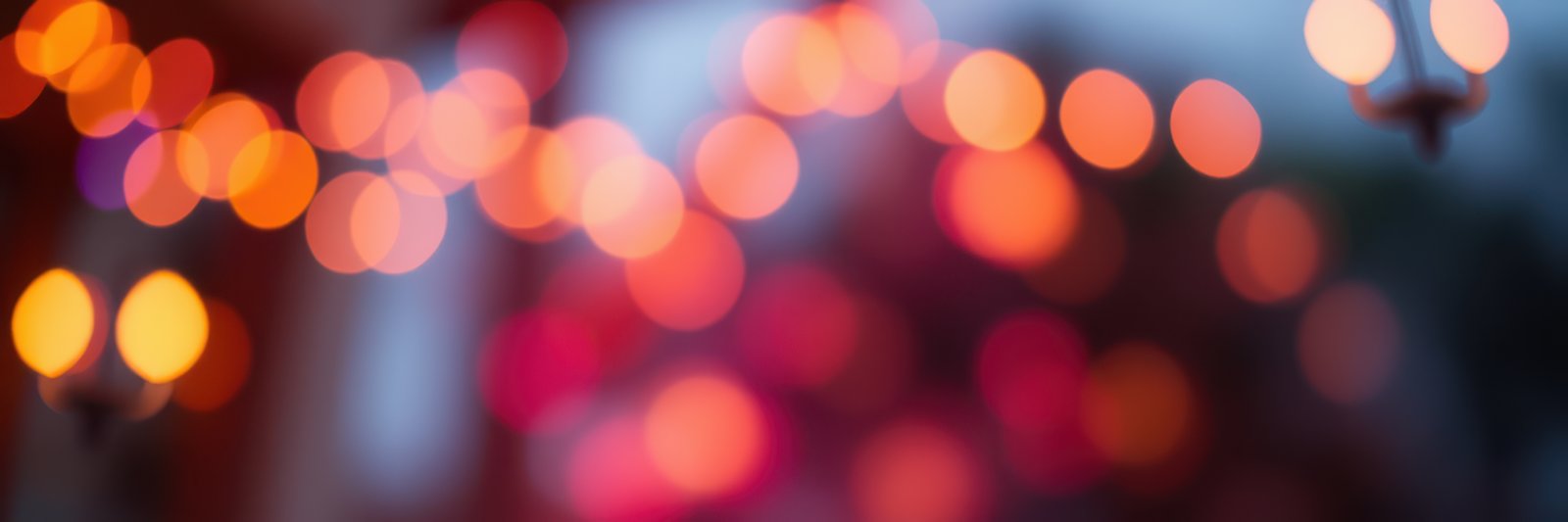 Brightly lit bokeh lights create a warm atmosphere during an evening gathering at a festive outdoor event